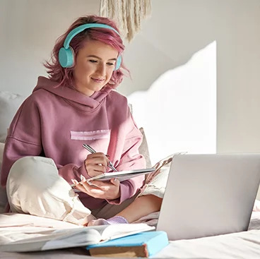 RISE - girl with headphones using laptop computer