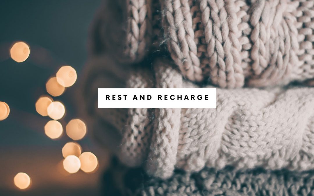 stack of sweaters with the words rest and recharge