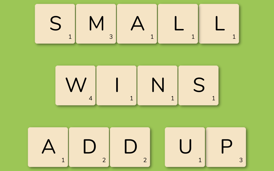 Scrabble tiles laid out on a green background. Tiles spell out the phrase "small wins add up."